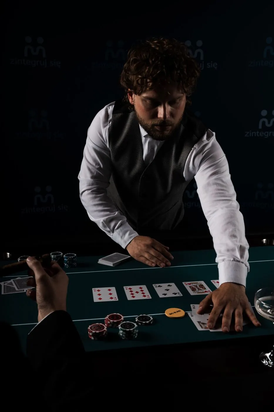 Krupier rozdaje karty przy stole pokerowym