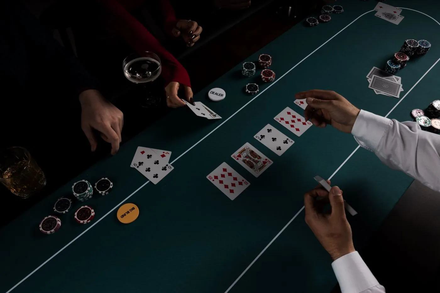 Krupier odkrywa karty na stole pokerowym
