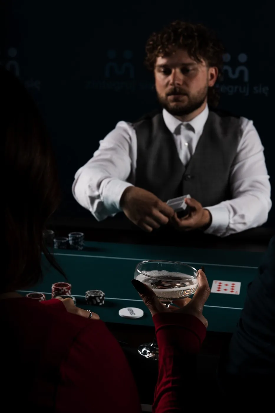 Krupier Zintegruj się tasuje karty przy stole pokerowym